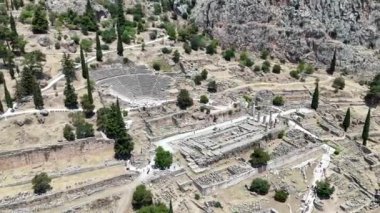 Delphi, Phocis / Yunanistan. Delphi Antik Tiyatrosu. 5.000 seyirci kapasiteli tiyatro Apollo 'nun sığınağında yer almaktadır. Güneşli bir günde bulutlu bir gökyüzü ile panoramik manzara