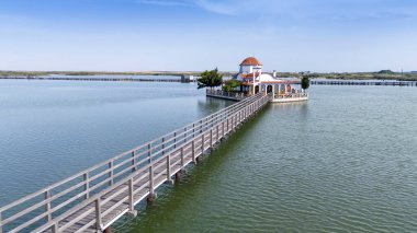 Yunanistan 'ın Porto Lagos kentindeki Vistonida Gölü üzerindeki Agios Nikolaos Manastırı üzerindeki hava aracı görüntüsü