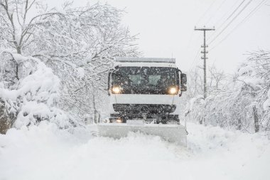 Kar küreme aracı sokaktan karı temizliyor.