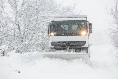 Kar küreme aracı sokaktan karı temizliyor.