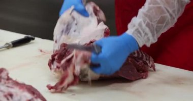 Et endüstrisi, kasap mezbahada bıçakla çiğ et kesiyor..
