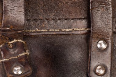 Perçinli ve dikişli deri ürünler. Resmin tüm yüzeyini kaplar. Yakın plan..