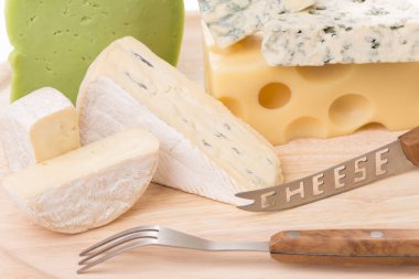 Tahta bir tabakta farklı peynirler seti. Resmin tüm yüzeyini kaplar. Yakın plan..