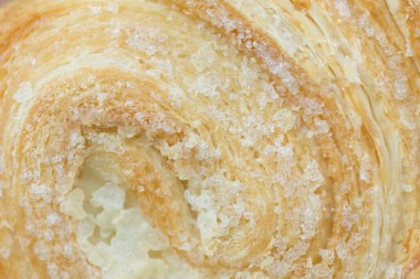 Puff pastry swirls with sugar. It occupies the entire surface of the image. Close-up. clipart