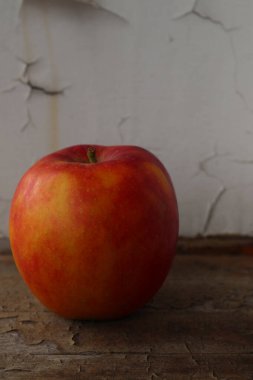 Bal gevreği çeşitlerinden olgun elma. Eski bir ahşap pencere pervazında yer alır. Yakın plan..