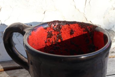 El yapımı siyah seramik kahve fincanı. Bir kabuk soyma duvarının arka planında yer alır. Yakın plan..