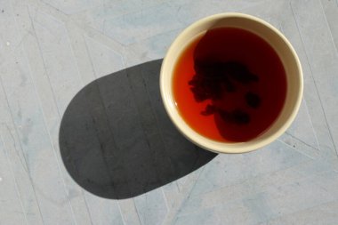 Siyah çay ile Çin çay fincanı. Bir ışık demeti fincanı aydınlatır. Yakın plan..