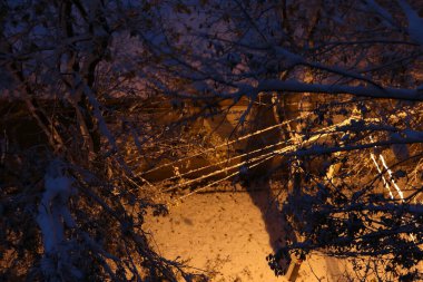 Kar yağışı sonrası kentsel kış manzarası. Karla kaplı bir şehir caddesi, karla kaplı ağaçlar. Yukarıdan bak. Bulutlu bir kış günü, yumuşak bir ışık.