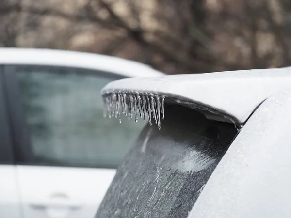 Icy spoiler of a white car close-up