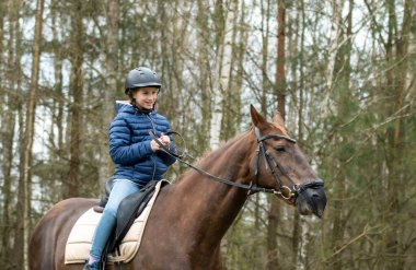 A girl in a helmet on a horse ride
