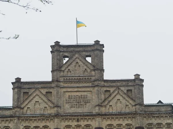 Ancient brick building with Ukrainian flag in Kyiv park