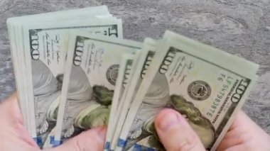 Yeni modelin 100 dolarlık banknotlarını sayıyorum.