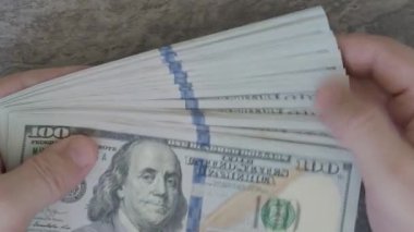 Yeni modelin 100 dolarlık banknotlarını sayıyorum.