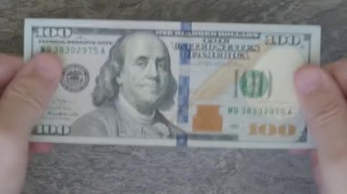 Yeni modelin 100 dolarlık banknotlarını sayıyorum.