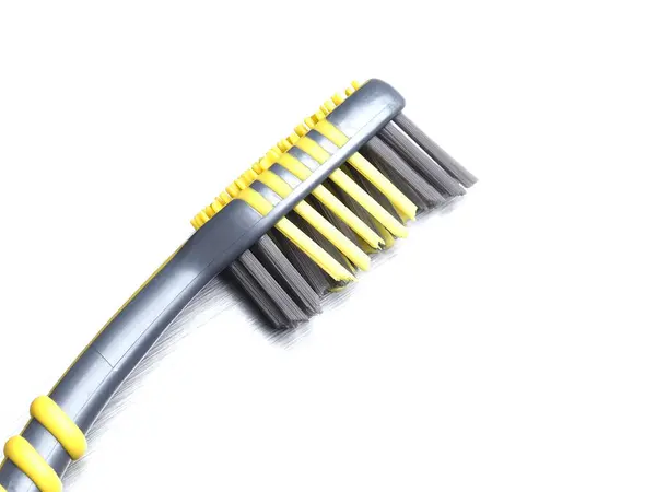 Graue Zahnbürste Mit Schwarzen Und Gelben Borsten Auf Einem Metallhintergrund — Stockfoto