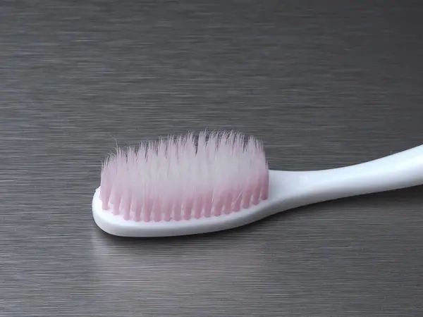Weiße Zahnbürste Mit Rosa Borsten Auf Einem Metallhintergrund — Stockfoto