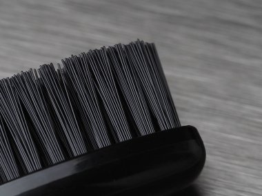 Metal arka planda siyah tüylü siyah diş fırçası.