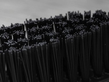 Metal arka planda siyah tüylü siyah diş fırçası.