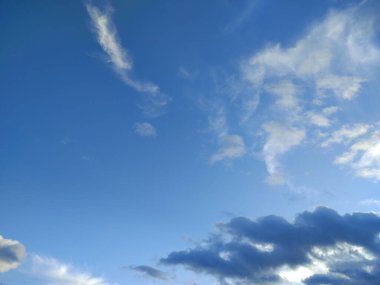 Mavi gökyüzü güneşle aydınlanır birkaç beyaz bulutla