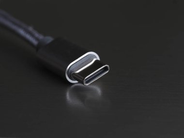 Koyu arkaplan üzerinde USB Tip-C kablosu, yakın plan, seçici odak