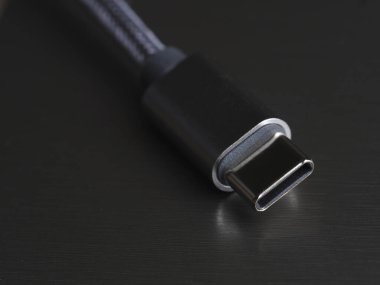 Koyu arkaplan üzerinde USB Tip-C kablosu, yakın plan, seçici odak