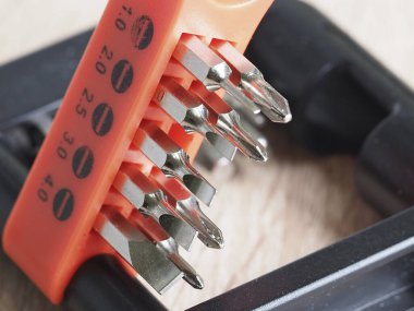 Ahşap bir masanın üzerindeki elektronik aletleri tamir etmek için bir takım parçalar.