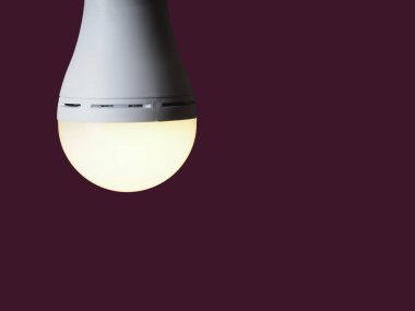 Bordo bir arka planda bulunan birinin elinde açık bir LED şarj edilebilir lamba.