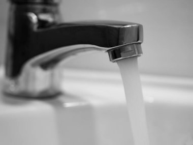 Banyodaki musluk açık, su akıyor.