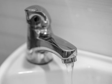 Banyodaki musluk açık, su akıyor.