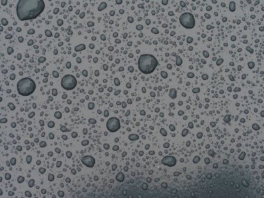 Pürüzsüz bir yüzeyde su damlacıkları ve ışık yansımaları soyut bir model oluşturur