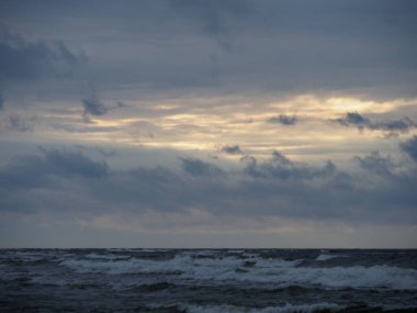 Sea During Stormy Dawn/Dusk with Dramatic Sky and Glimpses of Light clipart