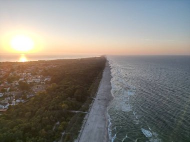 Deniz, Orman ve Kasaba Manzarası ile sahil şeridinde gün batımı