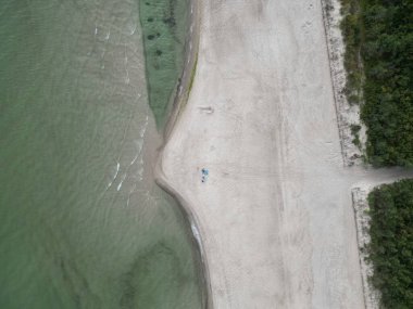 Su ve Kum Kıyısındaki İki Kişi ile Terkedilmiş Sahil Çizgisi 'nin Havadan Görüntüsü