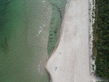 Güneşli bir günde Yeşil Sularla ve Küçük Dalgalarla Sahilin Hava Manzarası