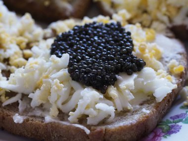 Gourmet Sandwich with Black Caviar, Egg, and Cheese for a Festive Breakfast clipart