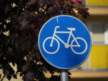 Sonbahar yapraklarına ve inşaata karşı bisikletçiler için yol işareti