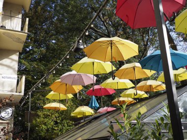 Renkli şemsiyelerden oluşan çatısı olan açık hava kafesi neşeli bir atmosfer yaratıyor.