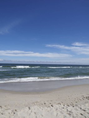 Beyaz kumlu ve mavi gökyüzü arka planlı okyanuslu sahil