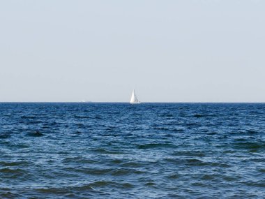 Sakin Mavi Deniz 'in Ufkunda Açık Gök Altında Yelkenli