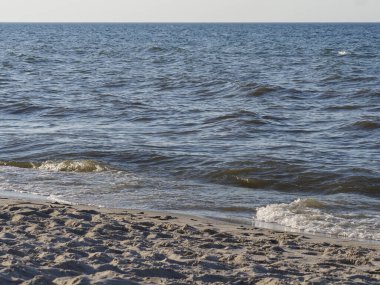 Gün batımında hafif dalgalar ve Sandy Shoreline ile Serene Coastal Beach