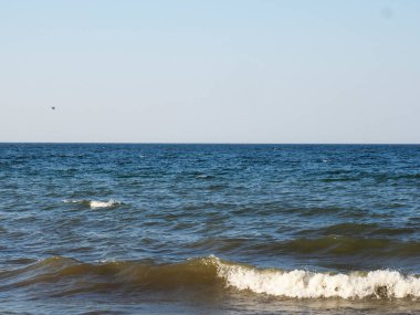 Serene Okyanusu Dalgaları Açık Mavi Gökyüzü ile güneşli bir günde çarpışıyor
