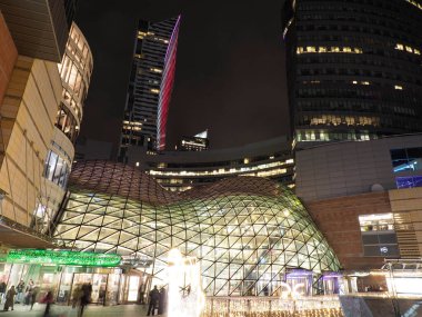 Geceleri aydınlık gökdelenleri ve cam kubbesi olan modern şehir mimarisi