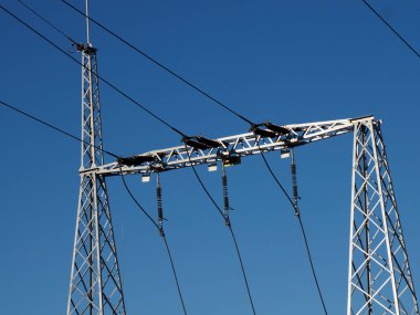 Açık Mavi Gökyüzüne Karşı İzolatörler ve İletkenlerle 115kV Kalkış Yapısı, Enerji İletimini Sembolize Ediyor
