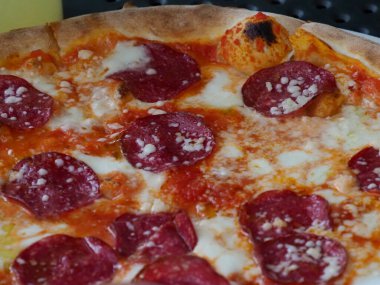 Eritilmiş peynirli ve kıtır kıtırlı ev yapımı Pepperoni Pizza. Geleneksel İtalyan mutfağının yakın çekimi.