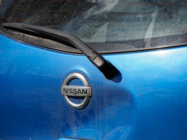 Mavi Araba Kaputu üzerindeki Nissan Logosunun Yakın Çekimi Japon Otomotiv Damlacıklarındaki Damlaları Gösteriyor