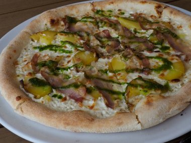 Yeşil otlu ev yapımı Sanatı Pizzası, Tahta Masada Sarı Sebze ve Et