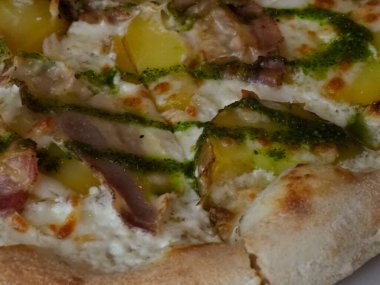 Köy ahşap arka planında taze ot, et ve sebzeli lezzetli gurme pizza.