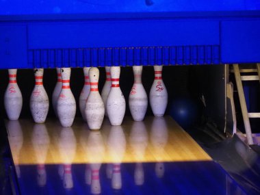Beyaz İğneli Profesyonel Bowling Alanı Mavi Ortam Işıklandırma Altında Parlak Ahşap Sokak 'ta Ayarlandı