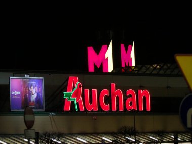 Aydınlatılmış Auchan Hipermarket İşareti Gece Koyu Pembe Gökyüzüne Karşı Logo