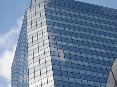 Geometrik Önyüzü Yansıyan Bulutlar ile Modern Cam Gökdelenin Çapraz Görünümü